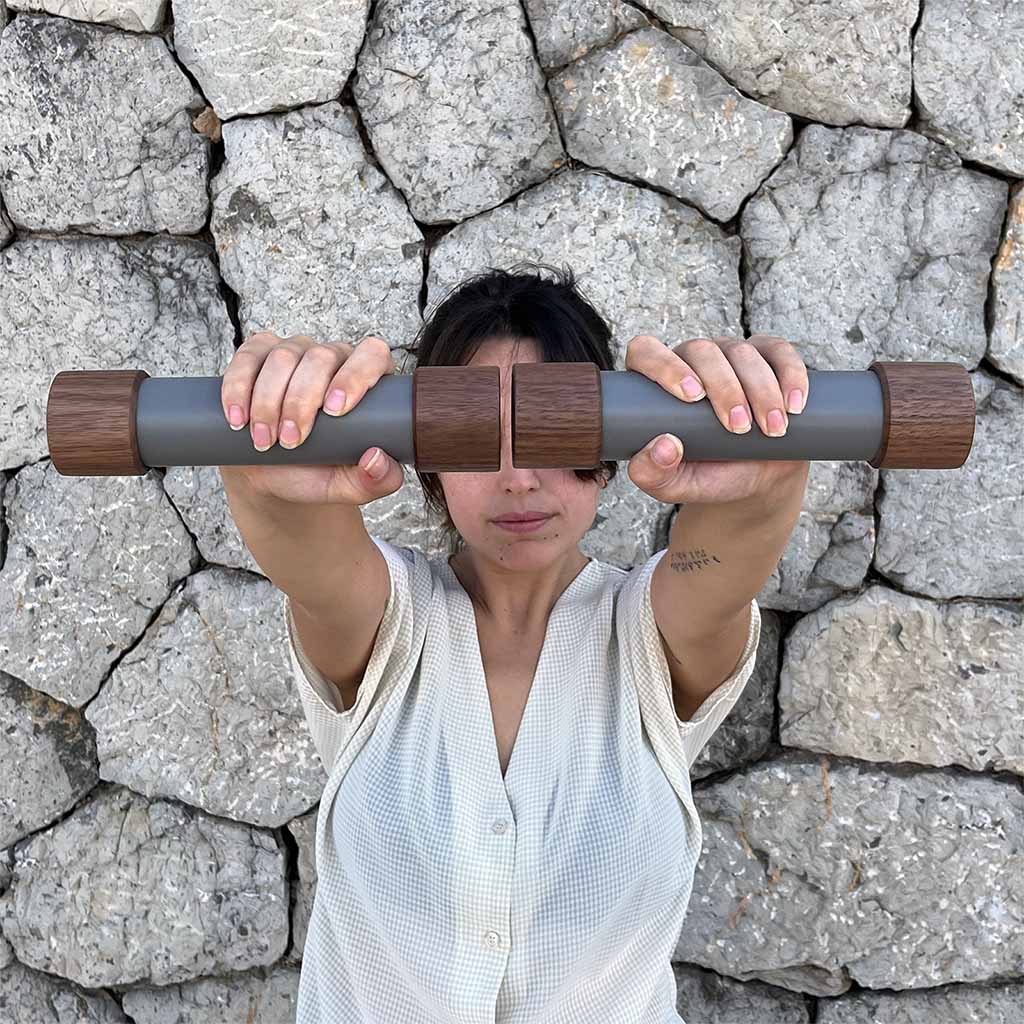 Woman modelling 1.5kg / 3lb dumbbells made from black american walnut wood and cast stone composite.